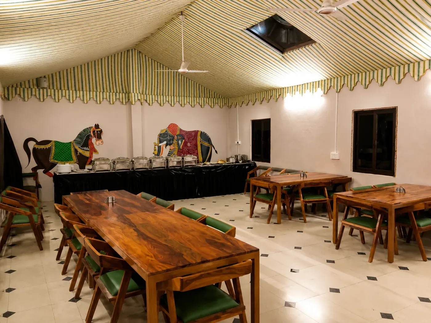 Spacious indoor dining hall with wooden tables, seating and traditional painted murals