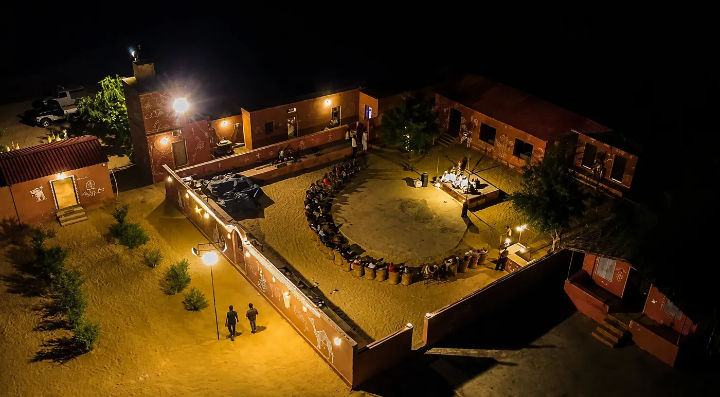 Aerial night view of open-air cultural amphitheater and cottage courtyard