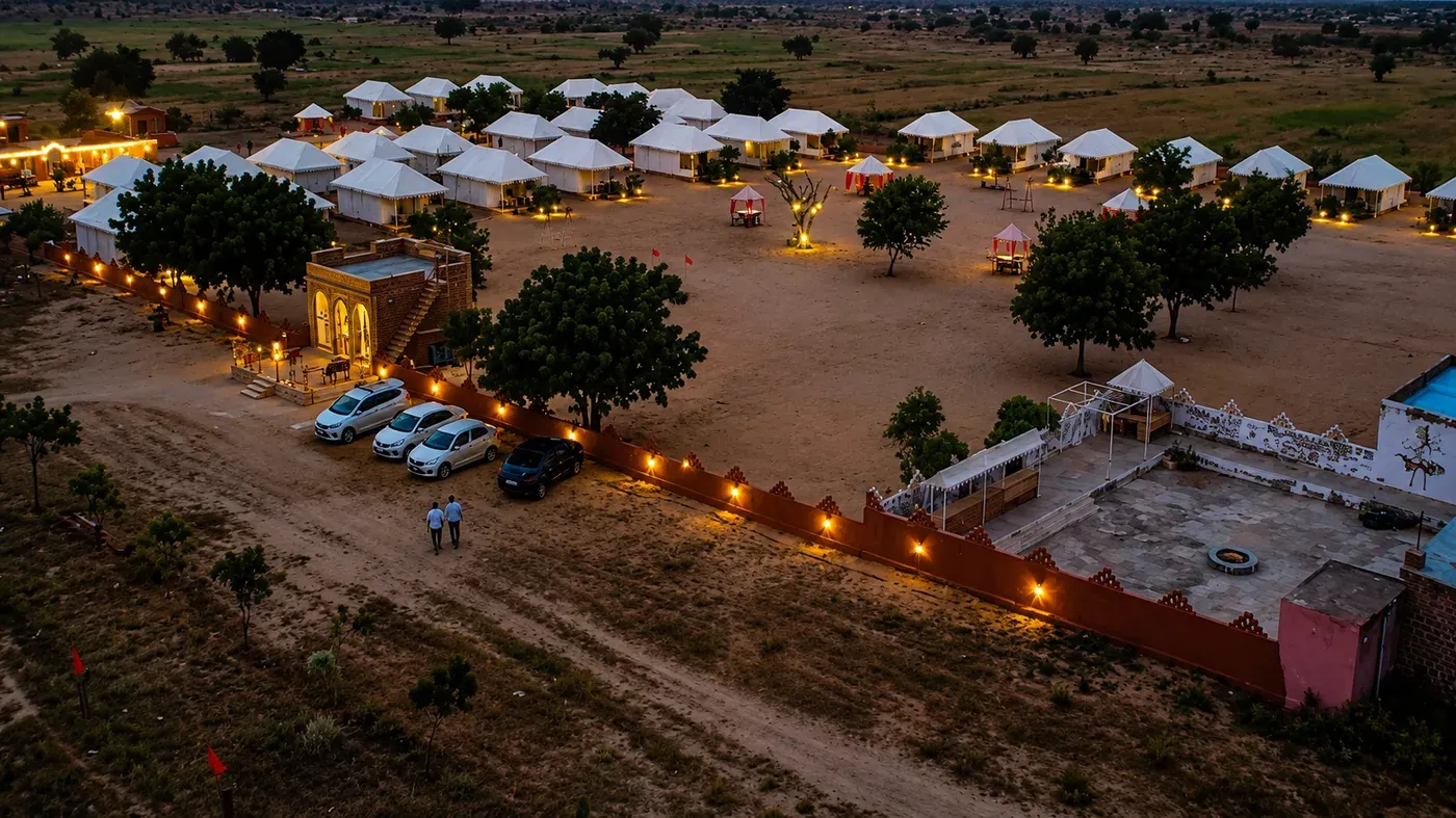 Twilight aerial view of Sunny Desert Camp showing perimeter lighting and tents