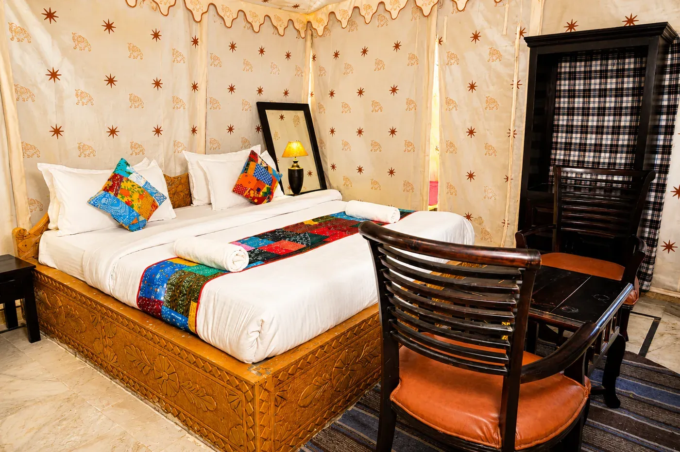 Super Deluxe Swiss Tent double bed with carved wooden frame and furnishings